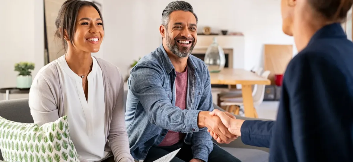 Multiethnic couple handshake with consultant at home